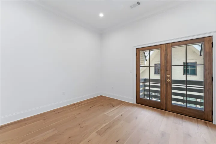This bright space offers rich hardwood flooring and french doors that open to a balcony.