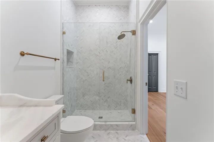 This bathroom features a contemporary shower with herringbone tile and sleek fixtures.