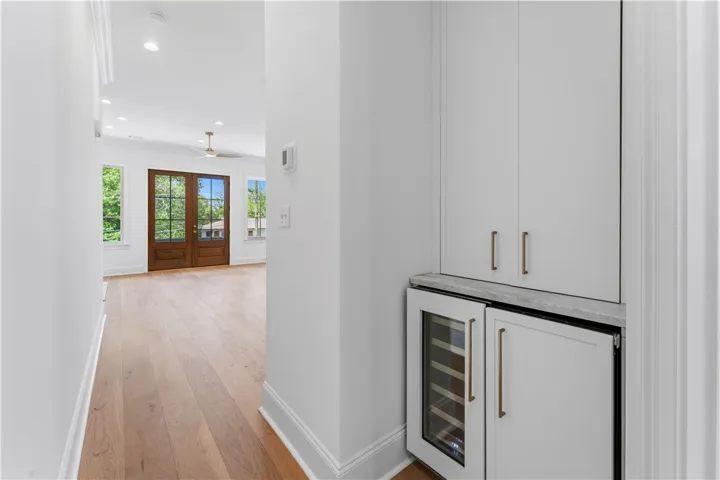 Elegant hardwood flooring extends through this open living space with French doors and modern amenities.