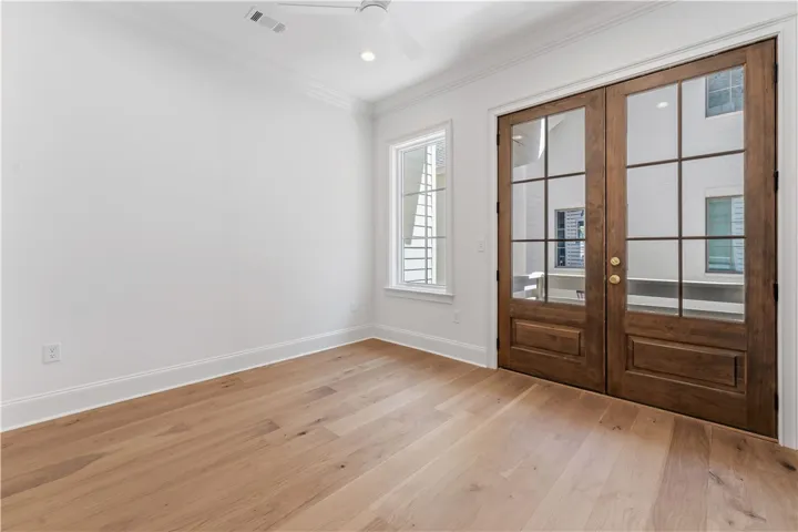 Bright, spacious room featuring elegant French doors and beautiful hardwood flooring.