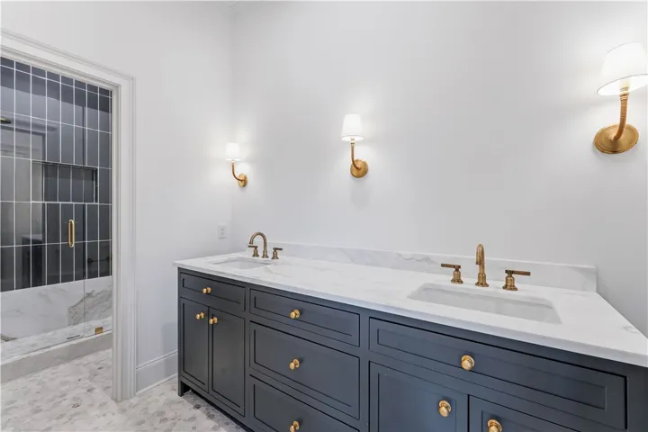 This modern bathroom features a stylish vanity and a spacious walk-in shower.