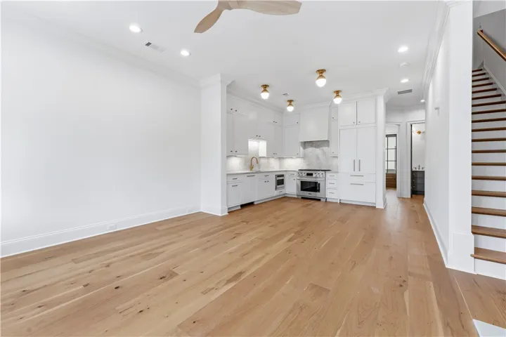 This bright, open concept space features a well-appointed kitchen and elegant hardwood flooring.
