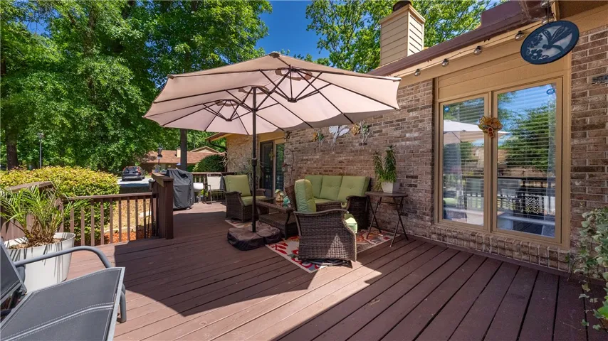 This spacious wooden deck offers an ideal setting for outdoor gatherings and relaxation.