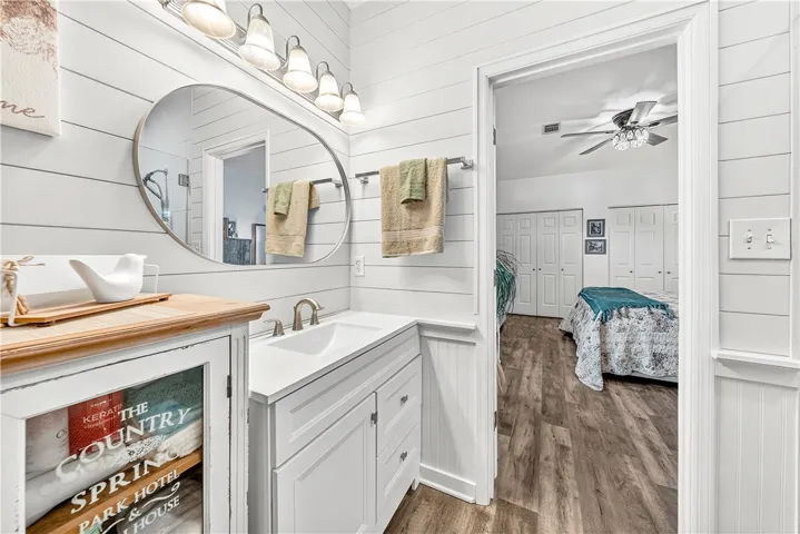 This bathroom features a sleek vanity and stylish fixtures, leading into a comfortable bedroom.