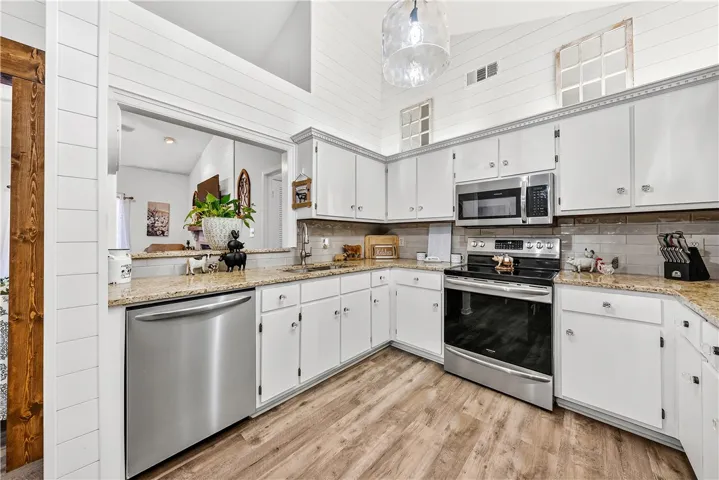 This modern kitchen features bright cabinetry, stainless steel appliances, and ample counter space.