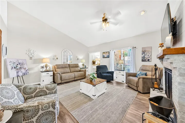 This inviting living room boasts vaulted ceilings and a cozy fireplace, perfect for relaxation and gatherings.
