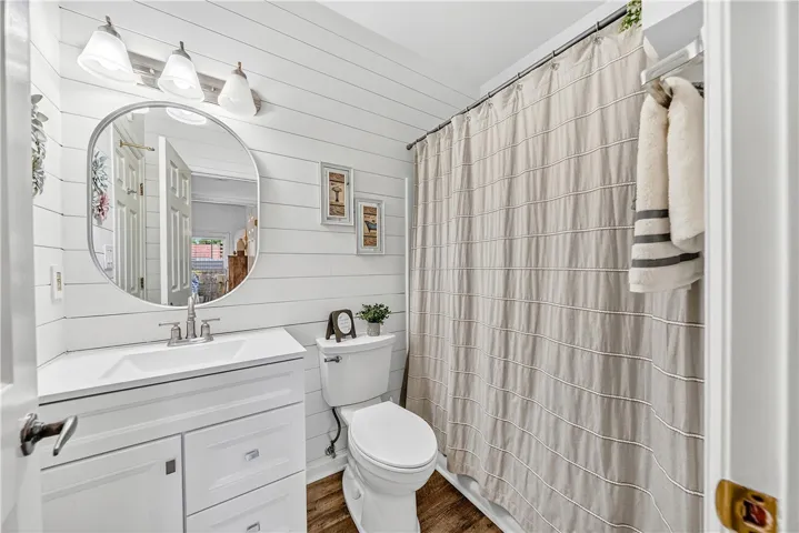 This bright bathroom features shiplap walls, a modern vanity, and practical fixtures for everyday comfort.