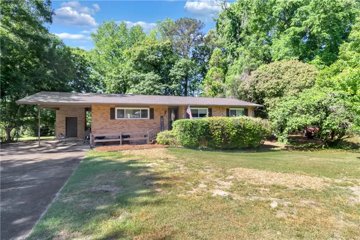 This charming residence features a brick exterior and an inviting carport.