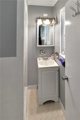This bathroom features a sleek vanity and a classic tiled shower.