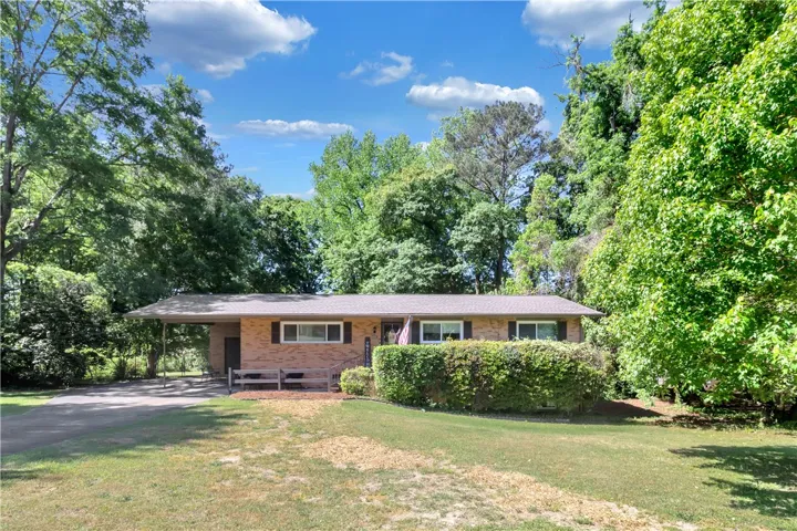 This charming residence features a classic brick exterior and a spacious front yard.