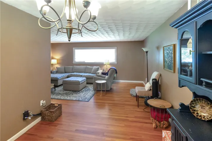 This inviting living area boasts rich hardwood flooring and ample natural light, perfect for relaxation.