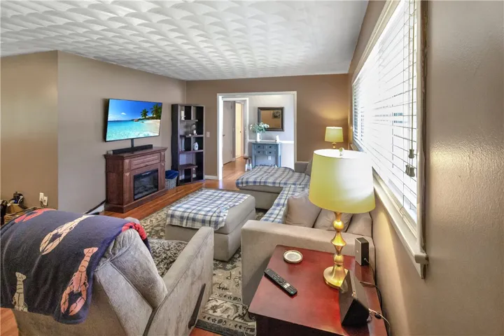 This inviting living area features warm wood flooring and a cozy fireplace, perfect for relaxation.