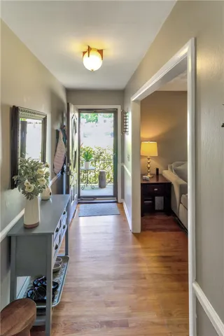 The welcoming entryway features rich hardwood flooring leading to an open living area.