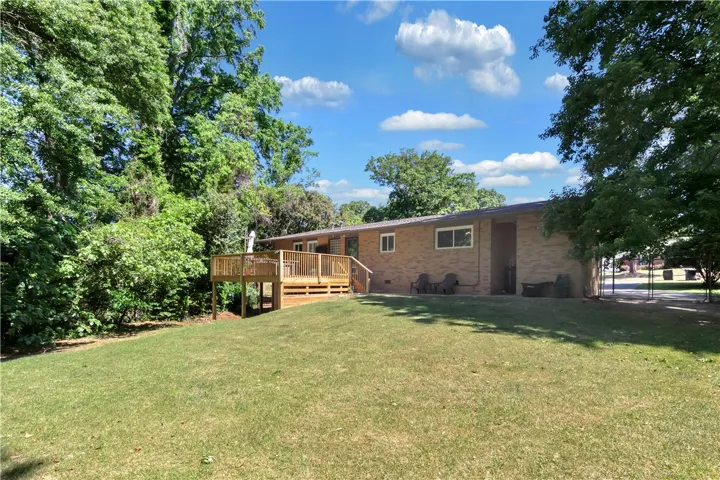 This residence features a spacious deck and an expansive yard, perfect for outdoor living and entertaining.