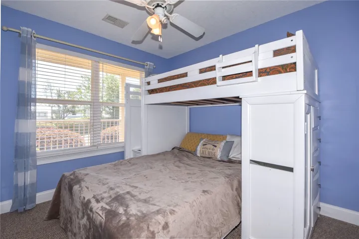 This cozy bedroom offers bright natural light and a built-in bunk bed, maximizing space with smart design.
