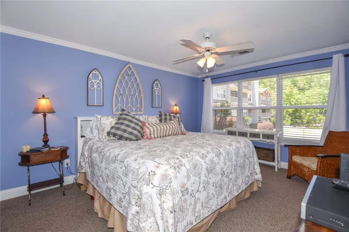 This spacious bedroom offers comfort with soft lighting and a bright, inviting atmosphere.
