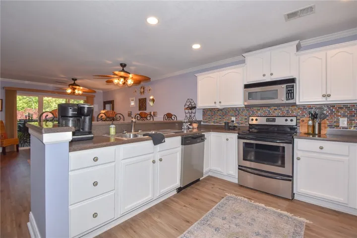 This spacious kitchen offers ample cabinet space and modern appliances, flowing into an open living area.
