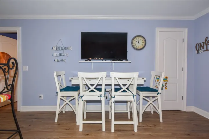 This inviting dining area features crown molding, enhancing the warm ambiance of the space.