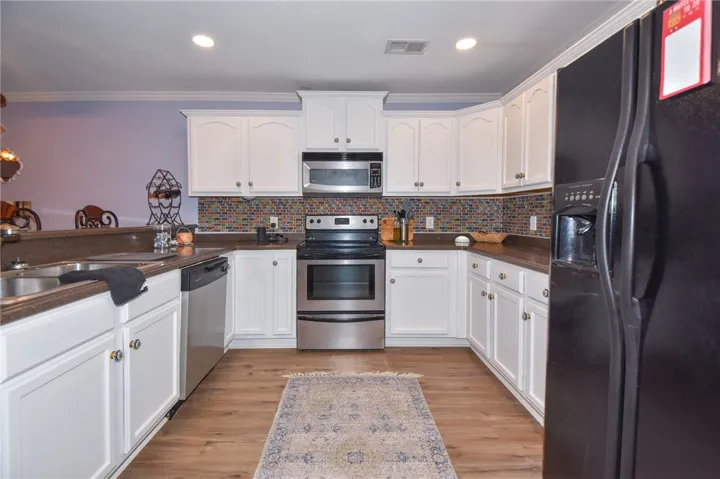 This spacious kitchen offers a U-shaped layout, bright cabinetry, and durable flooring for everyday living.