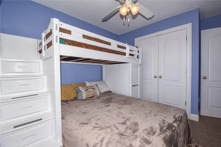 This cozy bedroom features clever bunk bed storage and durable carpeted floors.