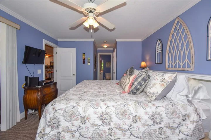 This tranquil bedroom features crown molding and carpet, creating a peaceful retreat.
