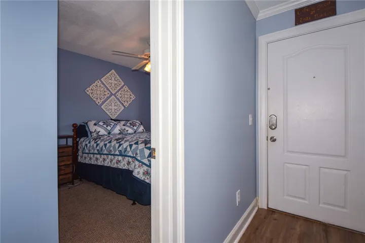 This inviting bedroom, visible from the hallway, promises serene comfort and a warm welcome home.