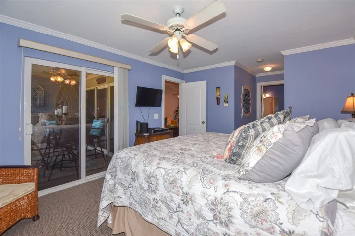 This spacious bedroom offers serene comfort with direct access to an outdoor retreat.