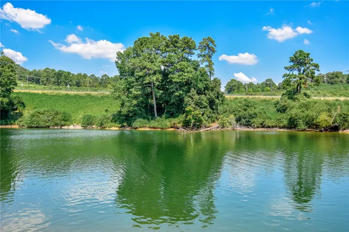 This tranquil waterfront setting provides a peaceful escape with lush trees and open skies.