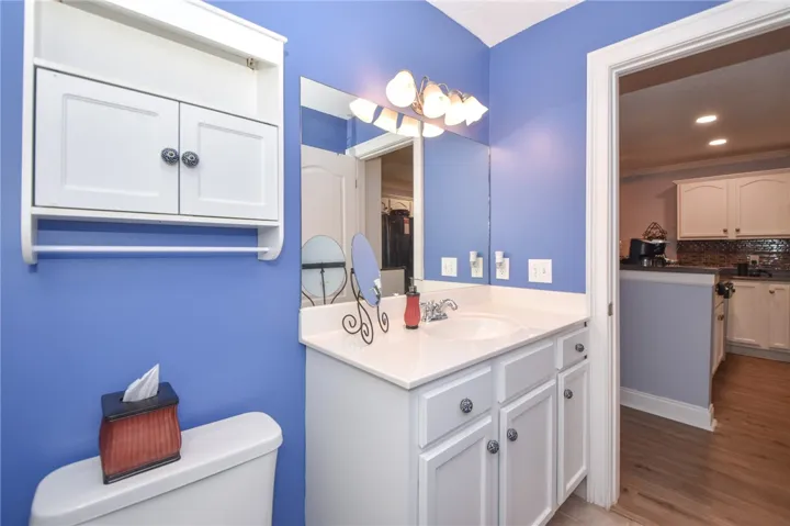 This bathroom features bright walls, a functional vanity, and a clean toilet, offering a fresh space.