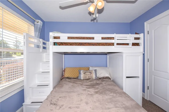 This cozy bedroom features built-in bunk beds with convenient storage, optimizing space and comfort.