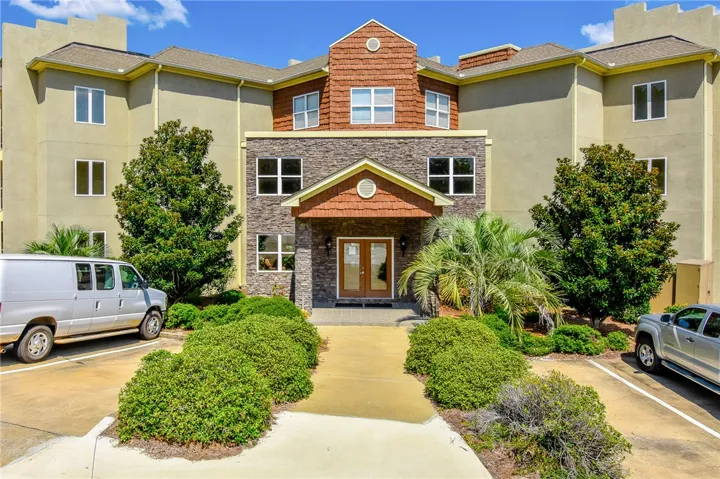 This charming condominium building features an inviting entrance with attractive landscaping.