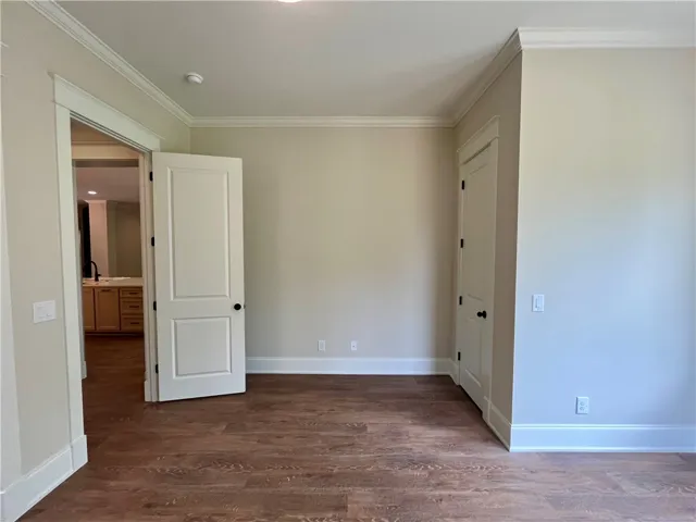 This versatile secondary bedroom boasts elegant hardwood flooring and classic crown molding, ready for your personal touch.