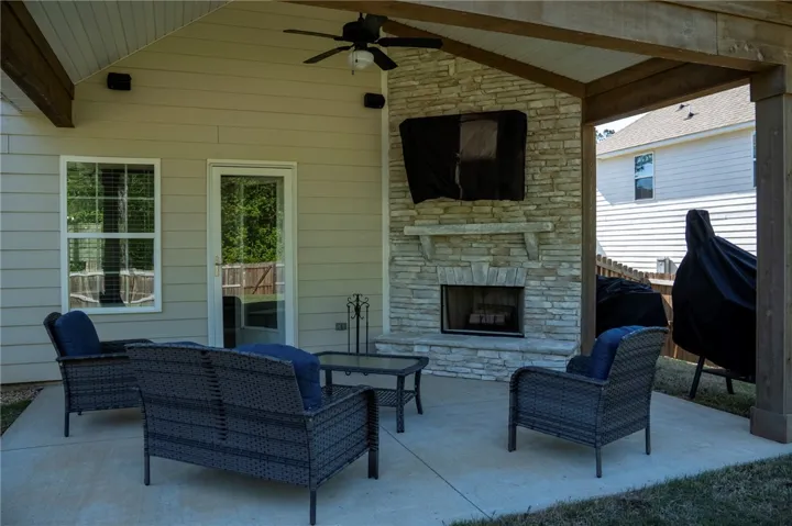 An inviting outdoor living area features a built-in stone fireplace, perfect for year-round enjoyment.