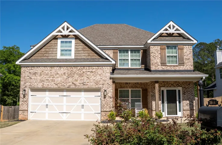 This charming home offers classic brickwork, a convenient garage, and inviting porch.