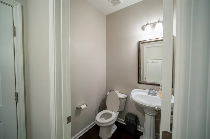 This clean and bright powder room features essential fixtures and a classic mirror.