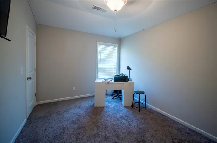 This cozy room features soft carpeting and a window, offering a versatile space for various needs.