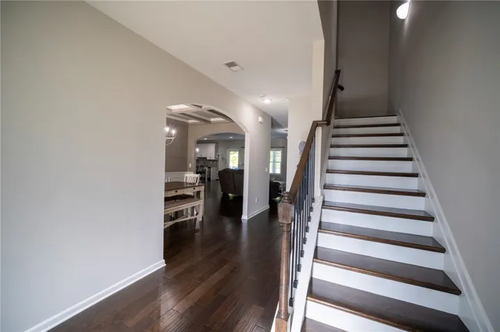 This inviting entry features gleaming hardwood floors and a striking staircase.