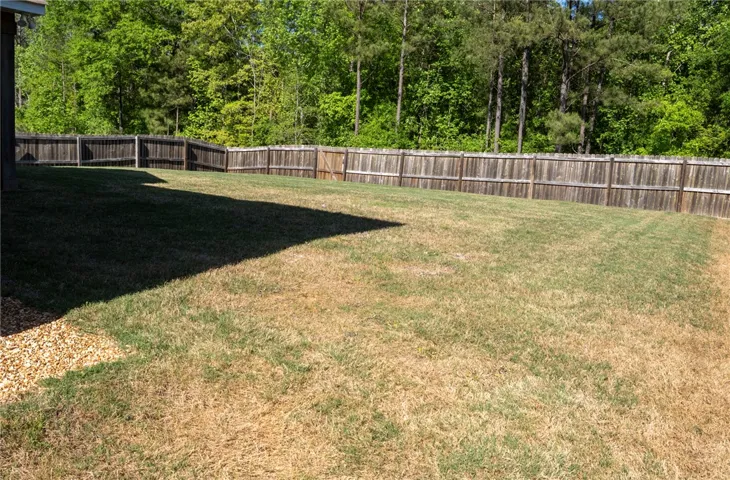 Expansive green space offers a serene private yard, perfect for outdoor enjoyment and relaxation.