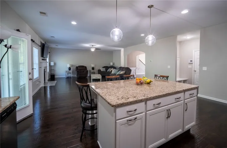 This inviting space offers a beautiful kitchen island, perfect for gathering, seamlessly flowing into the open living area.