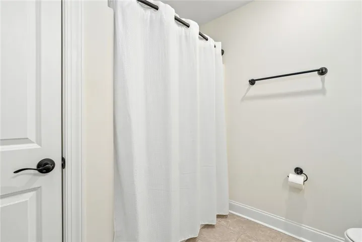 This clean and inviting bathroom features tiled flooring and essential fixtures for comfortable living.