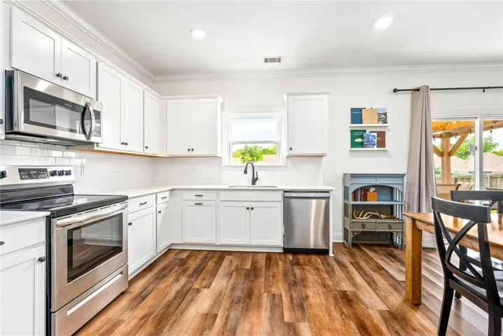 This modern kitchen features bright cabinetry, sleek appliances, and durable flooring.
