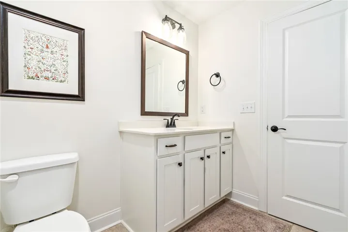 This bright bathroom features a spacious vanity with elegant hardware and ample storage.