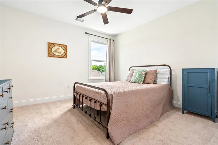 This cozy bedroom offers a tranquil retreat with soft carpet and a window inviting natural light.