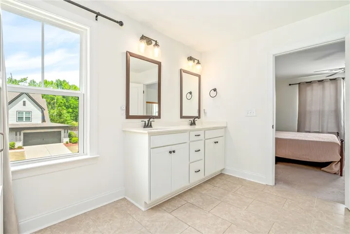 This bright bathroom features a double vanity and sleek fixtures, offering functionality and modern appeal.