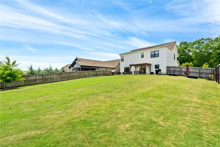 This expansive backyard offers ample green space and a delightful outdoor living area.