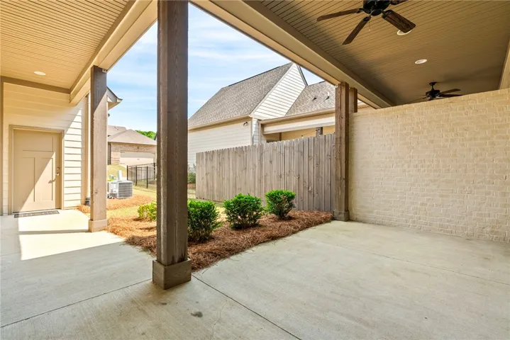 This outdoor patio provides a comfortable retreat with a covered ceiling and cooling fans.