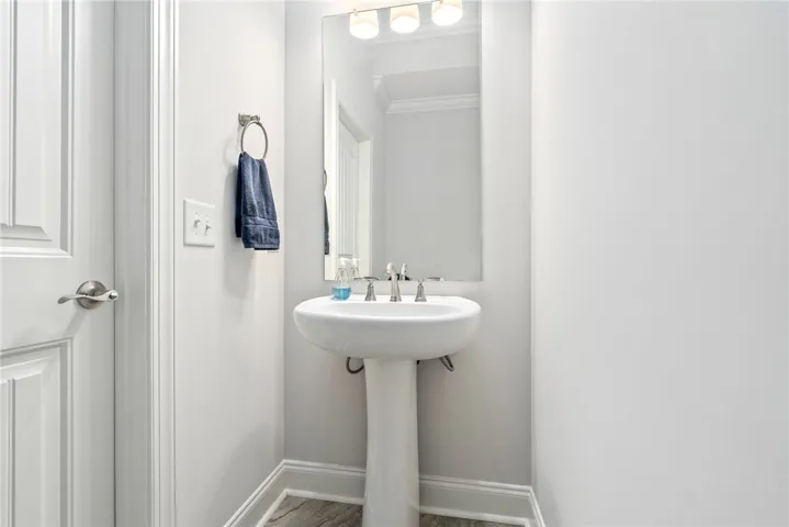 This sleek bathroom features a pedestal sink and modern finishes, perfect for any contemporary home.
