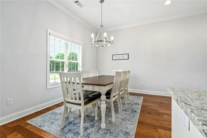 This bright dining area features elegant hardwood flooring and ample natural light.