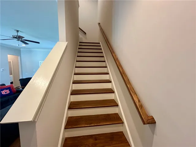 This interior staircase features wood treads, white risers, and natural wood handrails.