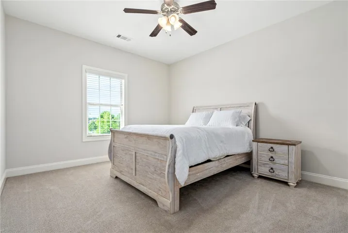 This tranquil bedroom offers comfort and a bright atmosphere for peaceful repose.